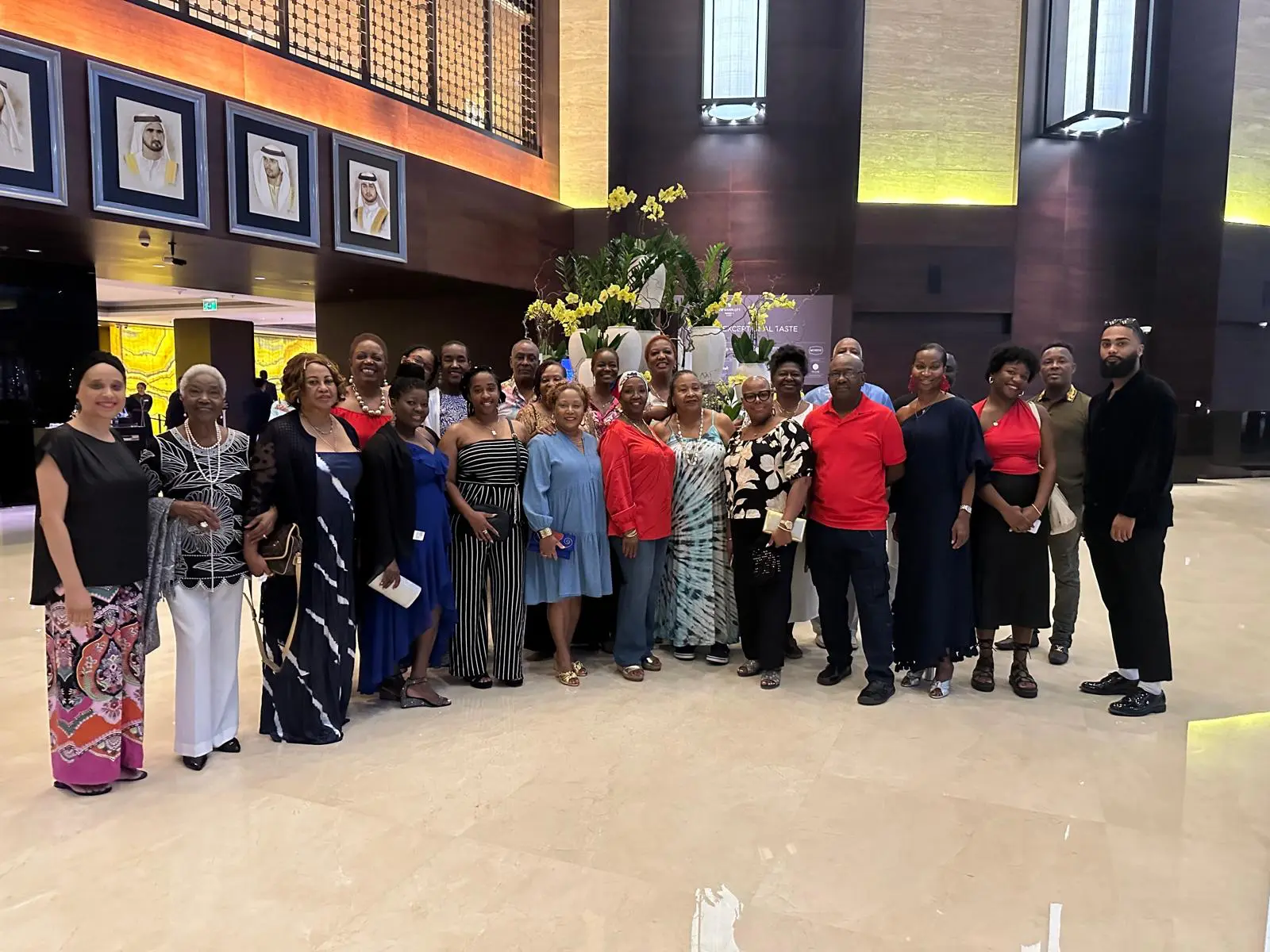 A large group of travelers posing together in a hotel lobby